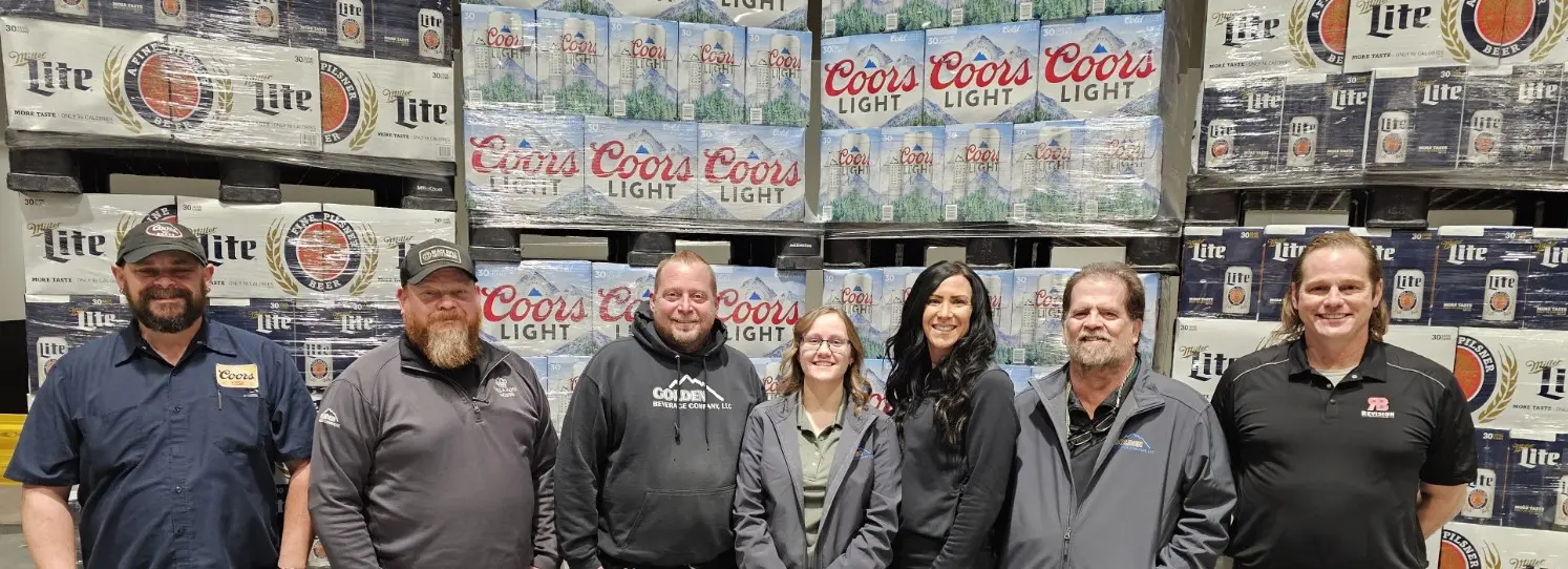 A group of people standing in front of beer cans.